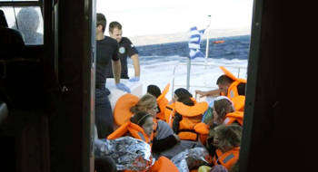 Many refugees wear life jackets on a Greek coast guard boat